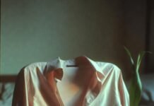 The Cultural Taboos Shaping Modern Intimacy Unbuttoned shirt, cracked phone, drooping plant, morning light.